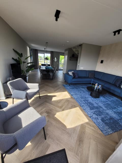 Wohnzimmer mit Ecksofa und Sesseln