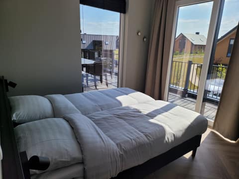 Schlafzimmer mit Doppelbett und Balkonzugang