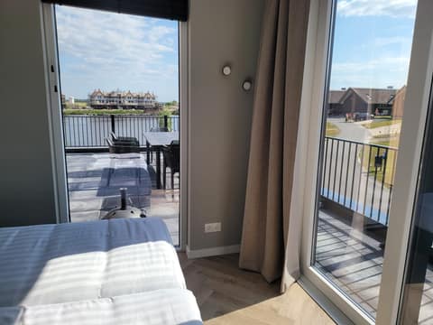 Schlafzimmer mit Blick auf Terrasse und Wasser